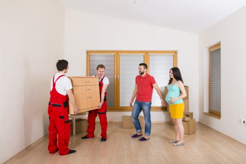 Movers carrying furniture through a Barnes residential street
