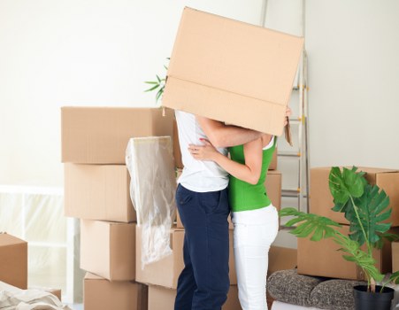 Packed boxes and furniture being loaded into a moving van
