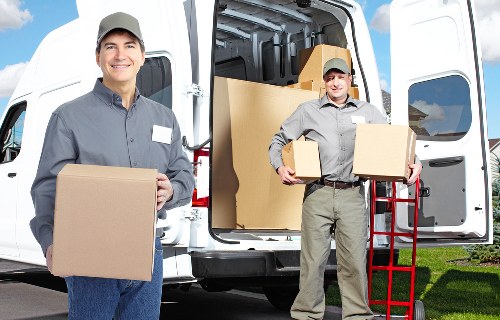 Trained removals staff carrying boxes safely in a property
